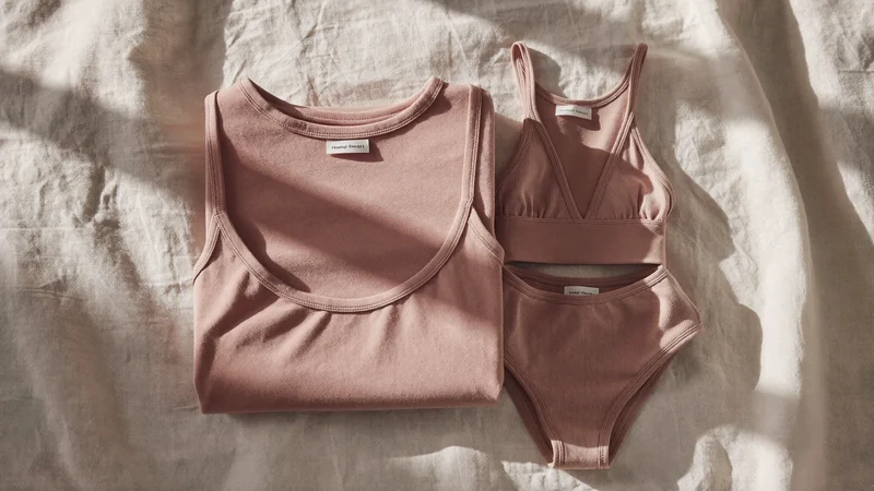 Body și set de bebeluș din bumbac organic împăturite pe in brut, în lumină difuză
